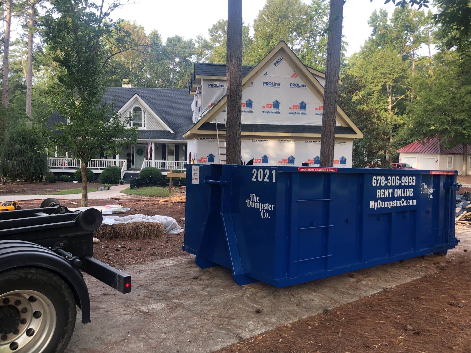 a blue dumpster next to a house