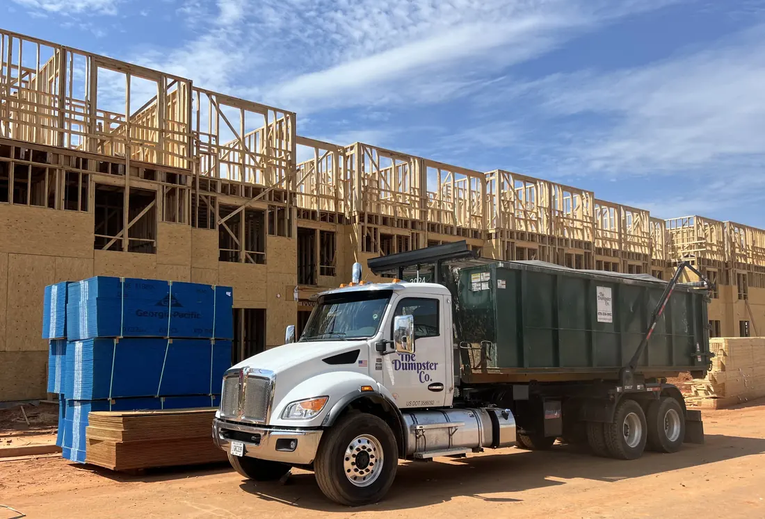 The Dumpster Co. roll-off truck at a multifamily new construction project